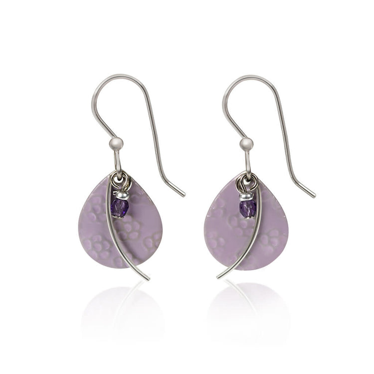 Drop earrings with a flower-textured silver tear shape, metal wisp arc accent, and dangling amethyst bead.