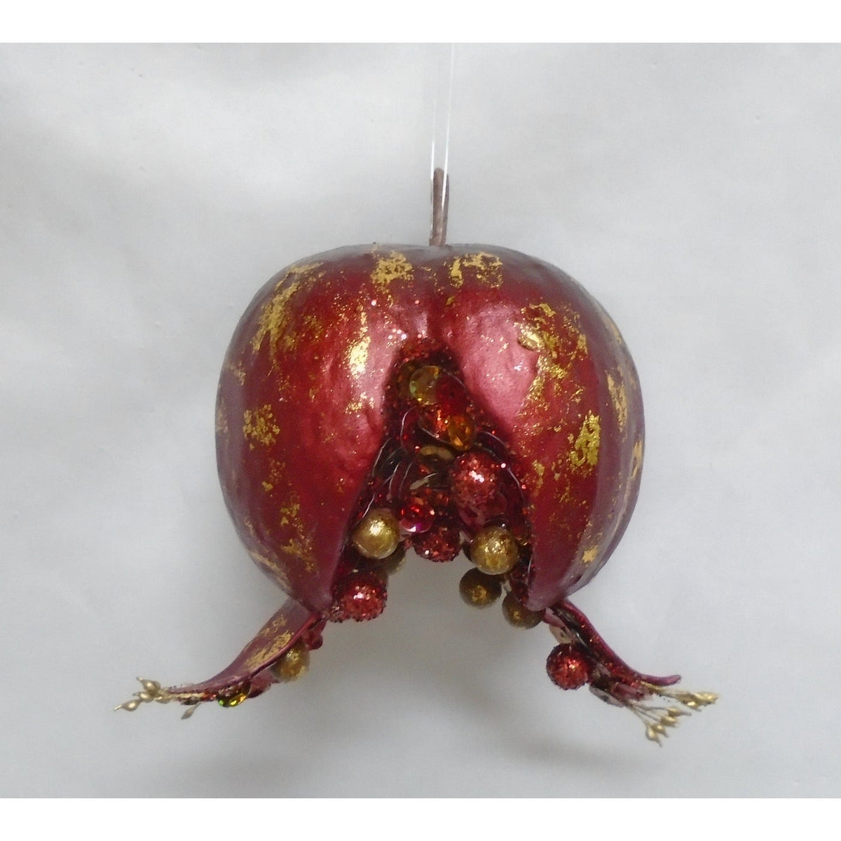 Tuscan medium open pomegranate ornament in red and gold with cascading bead-like seeds.