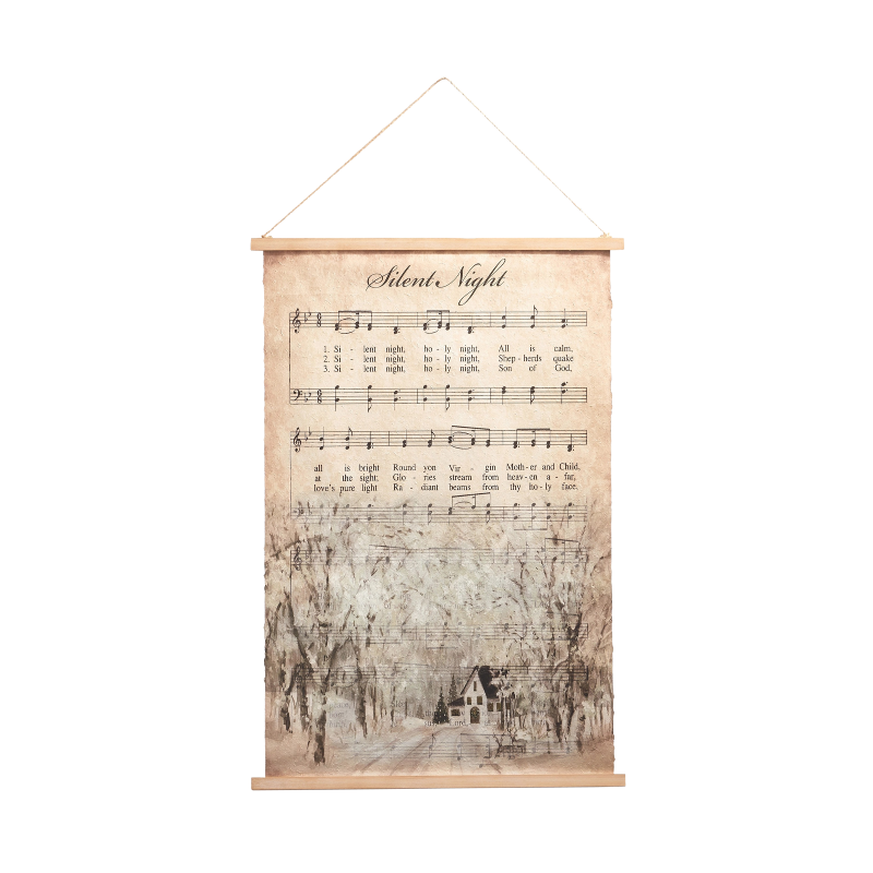 Hanging paper tapestry featuring Silent Night sheet music over a winter landscape with a cottage.