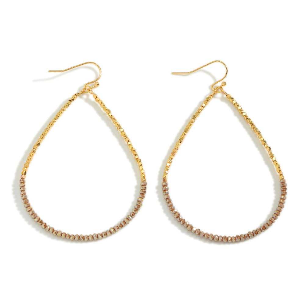 Long dainty teardrop earrings with gold and neutral faceted beads on gold-tone wire hooks.