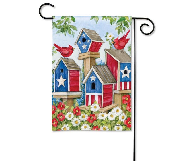 Garden flag with patriotic birdhouses and cardinals surrounded by flowers.