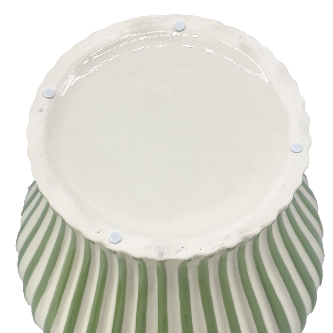 Bottom view of a green and white candy cane striped ceramic vase with four protective felt pads.