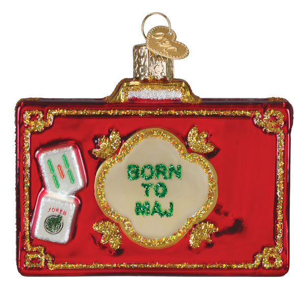 Red glass suitcase ornament with Mahjong tiles and green glitter text reading BORN TO MAJ.