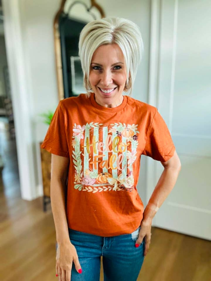 Woman wearing a rust-colored Alecia Boho Hello Fall Pumpkin Collage seasonal graphic tee.