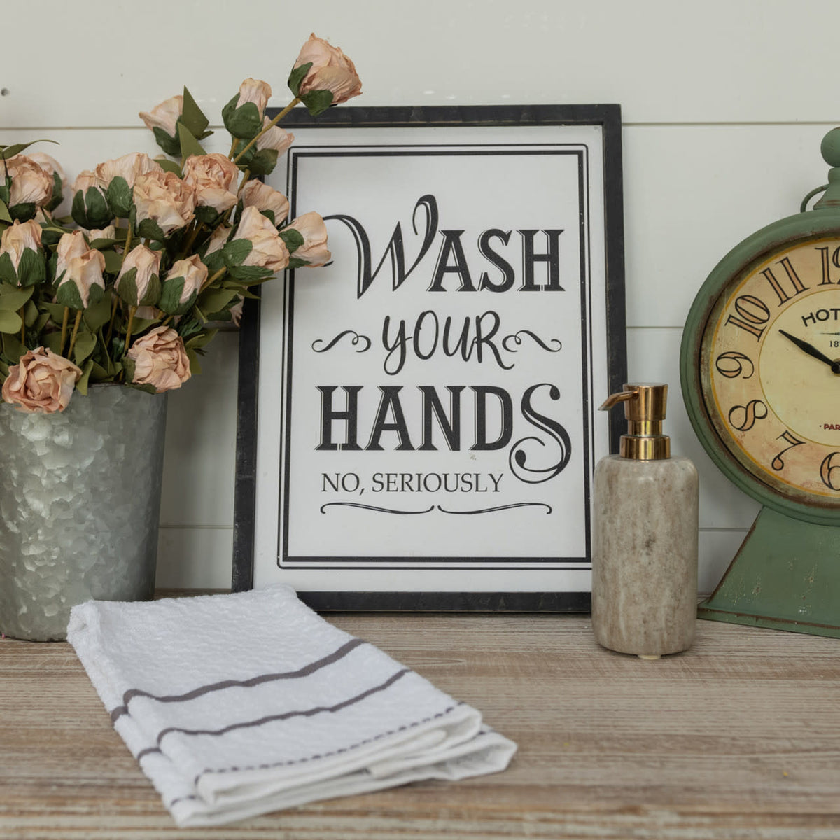 Wooden framed sign with white text reading Wash Your Hands on a light background
