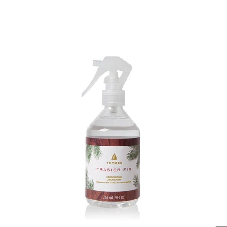 Bottle of Frasier Fir deodorizing linen spray with white label against neutral background.