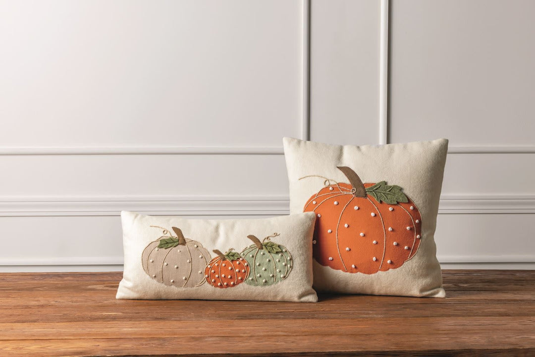 Eighteen-inch square felted wool pillow featuring a pumpkin appliqué with French knot embroidery and zipper closure.