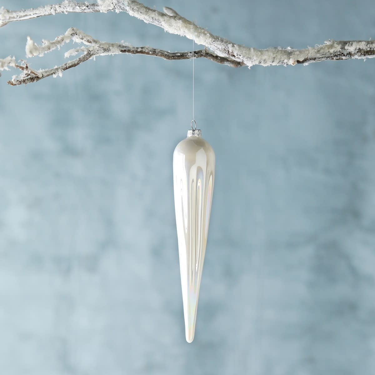 Elongated white glass icicle ornament with a pearlescent hand finish.