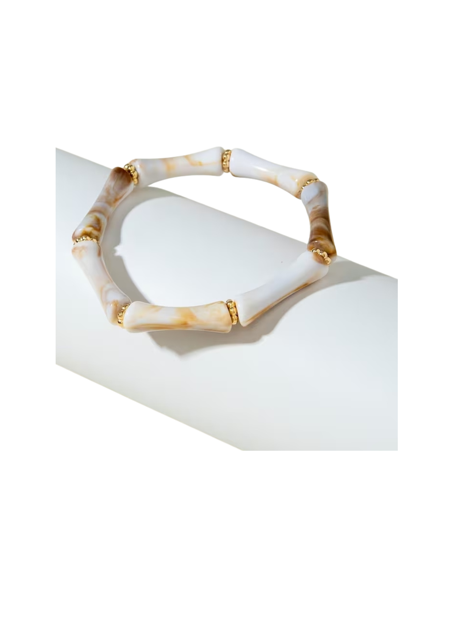 Resin beaded tube stretch bracelet with marbled white and tan curved beads and gold spacers.