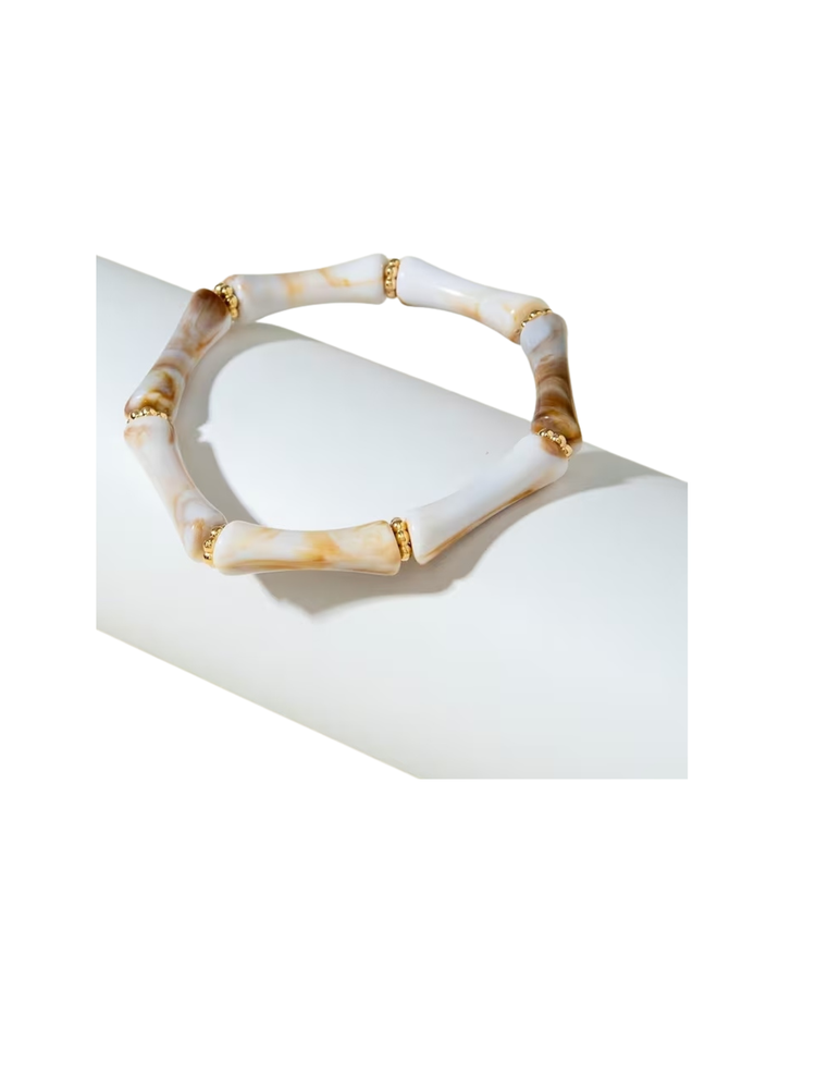 Resin beaded tube stretch bracelet with marbled white and tan curved beads and gold spacers.