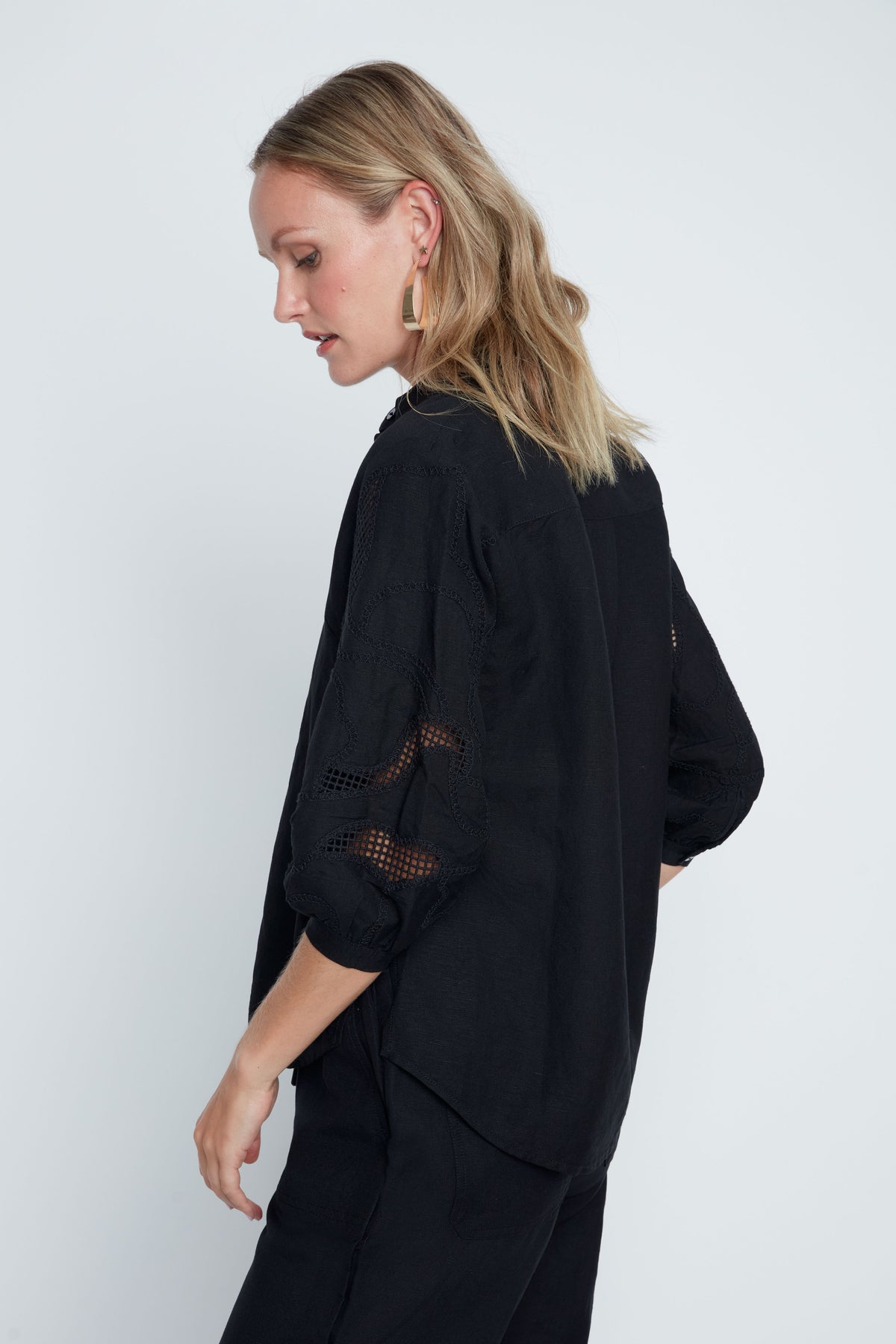 Hannah woven blouse in soft neutral tone with relaxed fit, button front, subtle textured sleeves, and sheer panel accents.
