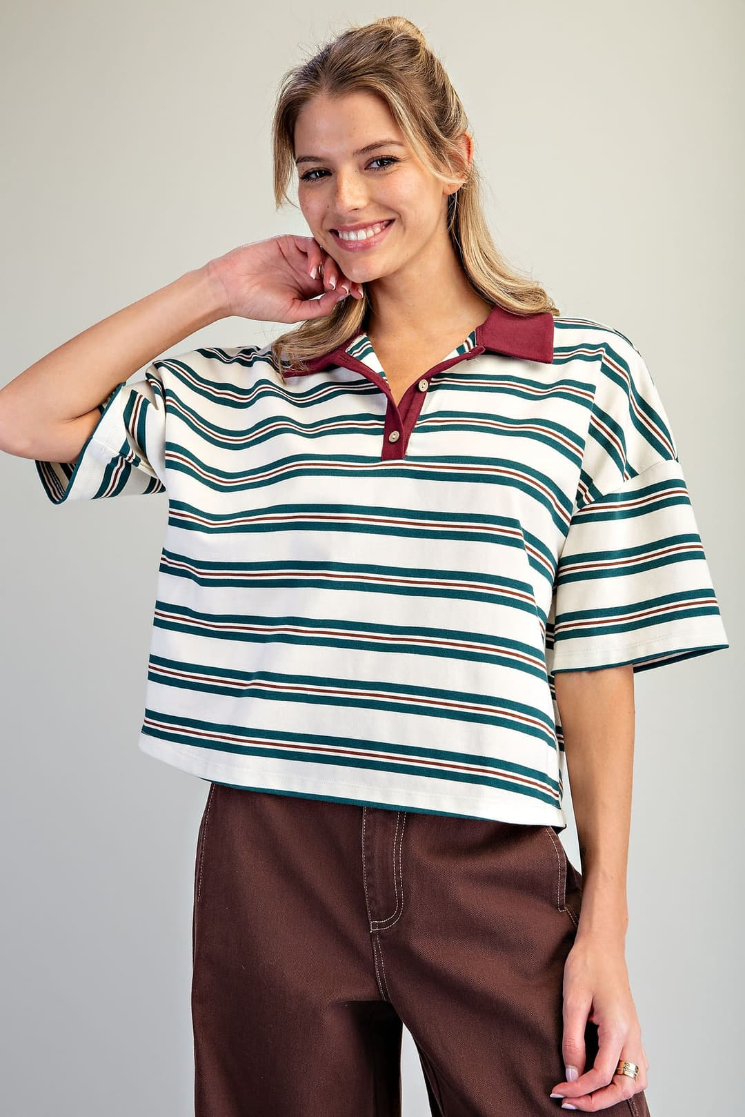 Woman wearing the Cecilia Forest striped oversized polo top with a burgundy contrast collar.
