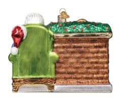 Back view of a Santa at Hearth glass ornament featuring Santa in a green chair by a brick fireplace.