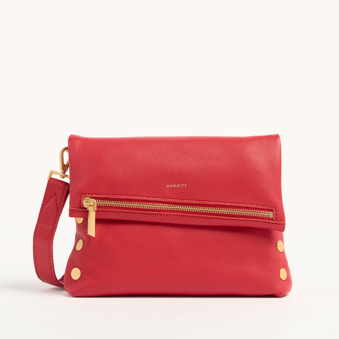 Medium zippered bag in buttery black leather with brushed gold rivets and a subtle red seam detail.