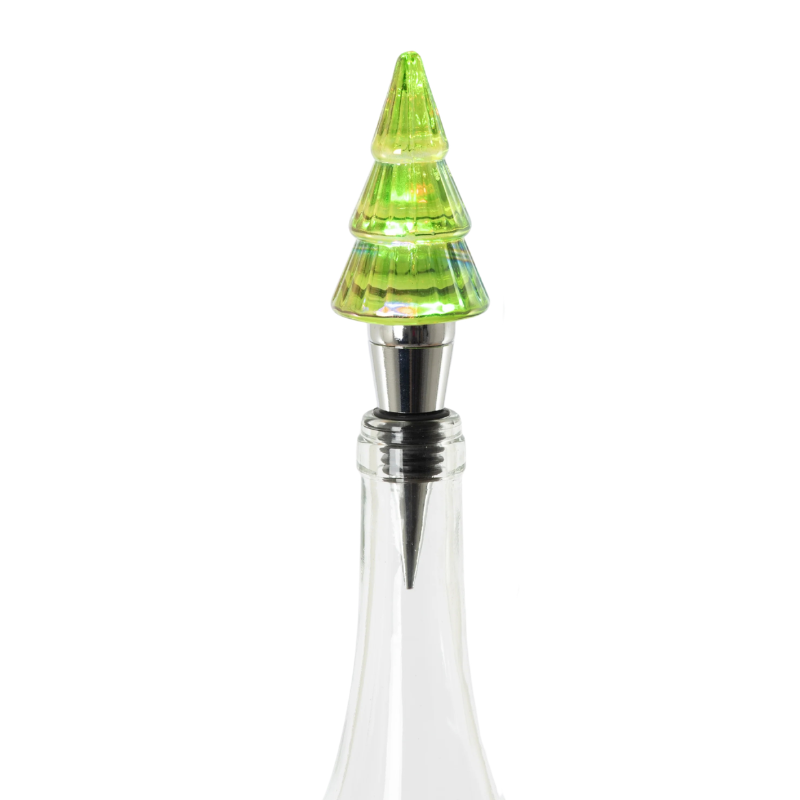 Lit green glass Christmas tree bottle stopper with a silver metal base in a clear glass bottle.