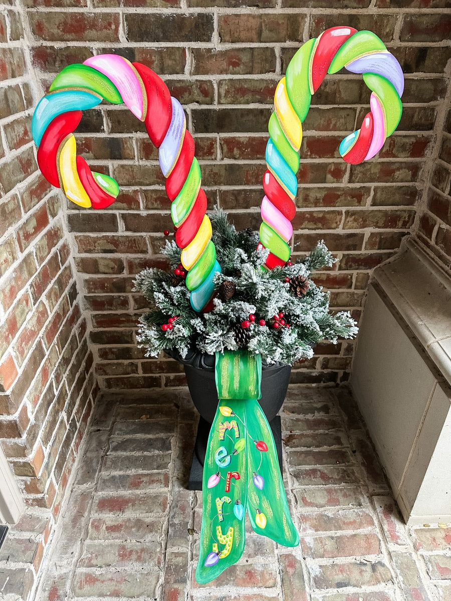 Large candy cane stake with red and white striped spiral pattern on a green background.