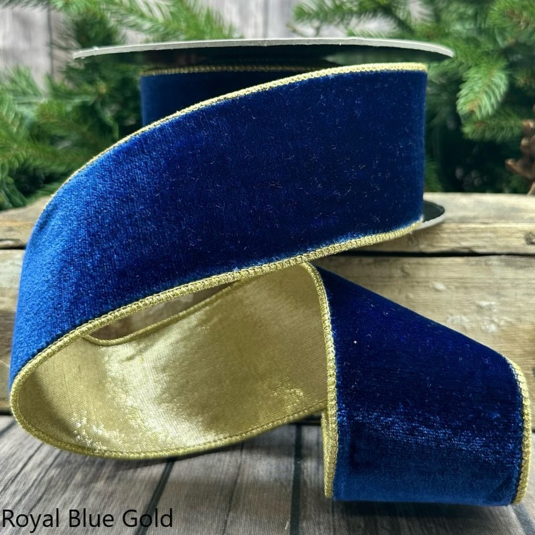 2.5-inch wide royal blue velvet ribbon with gold metallic edges on a spool.