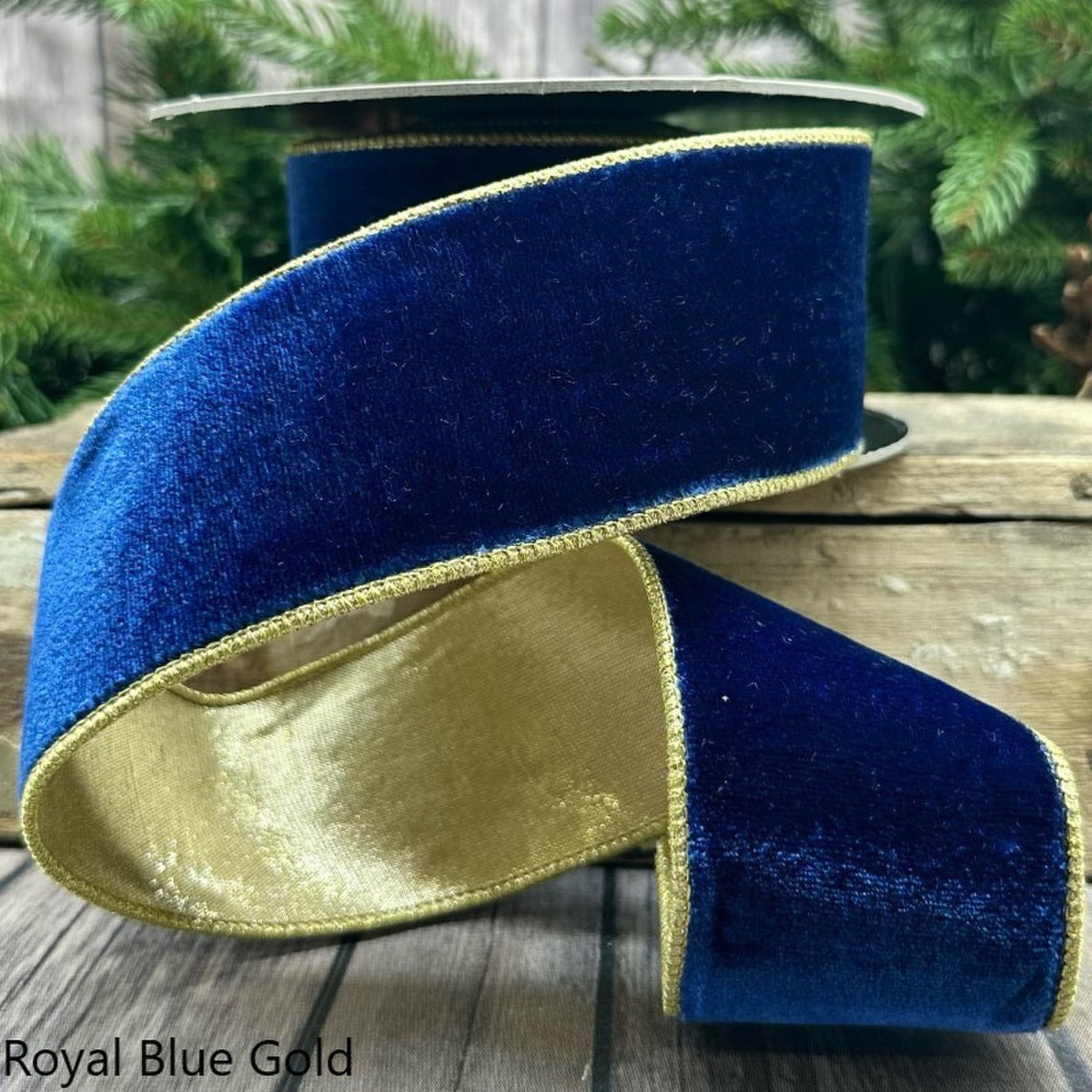 2.5-inch wide royal blue velvet ribbon with gold metallic edges on a spool.