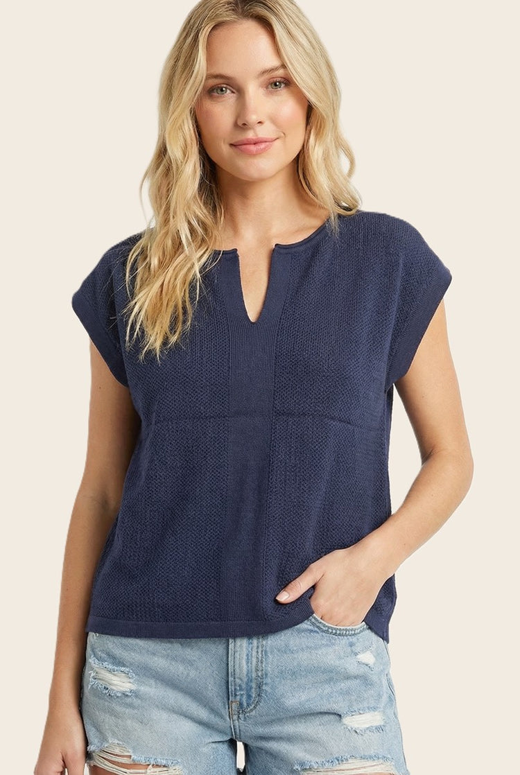 Woman wearing the Isabelle Pointelle Short Sleeve Sweater Top in navy blue with a slit neck.