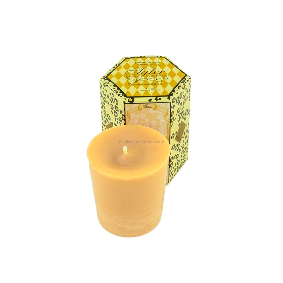 A 2oz Tyler votive candle in a yellow wax, placed in front of its hexagonal leopard print box.