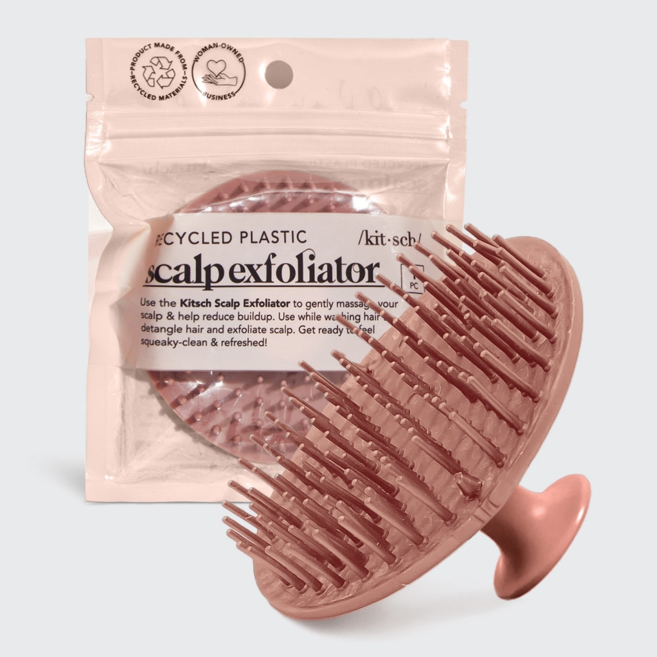 Black scalp exfoliator with flexible bristles made from recycled materials.