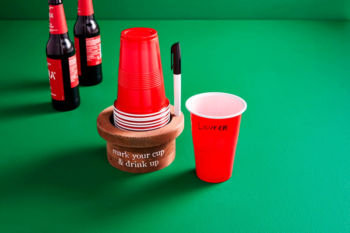 Set of white disposable cups with matching black marker pens.