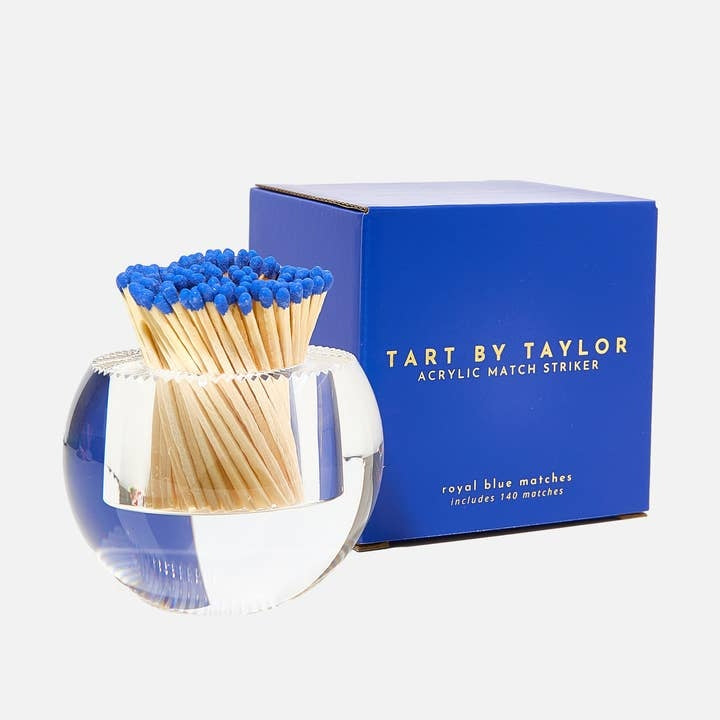 Round acrylic match striker with strike pad base holding a pack of matches