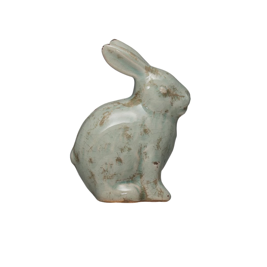 Distressed terracotta rabbit figurine with aqua accents in a seated silhouette.