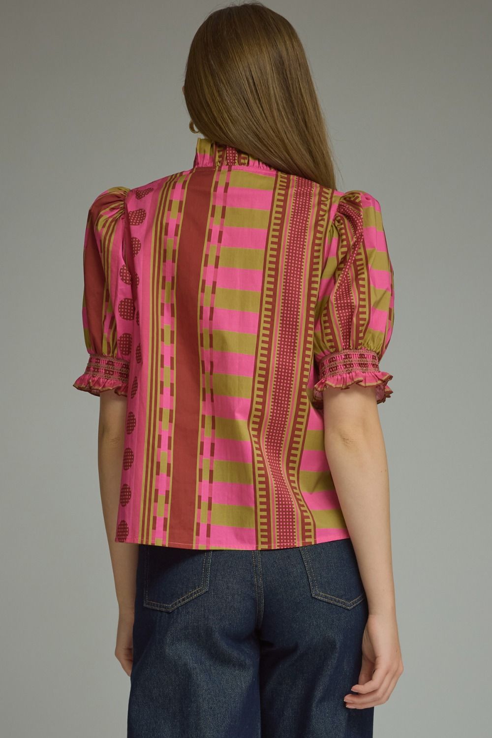 Back view of a woman wearing the Athena mixed print top with pink and olive stripes and puff sleeves.