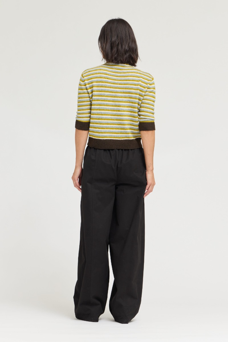 Back view of a person wearing a yellow and grey striped 7/8 sleeve sweater with brown trim.