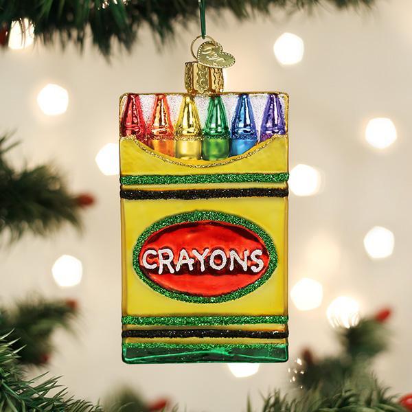 Glass box of crayons Christmas ornament hanging on a tree with six colorful crayon tips showing.