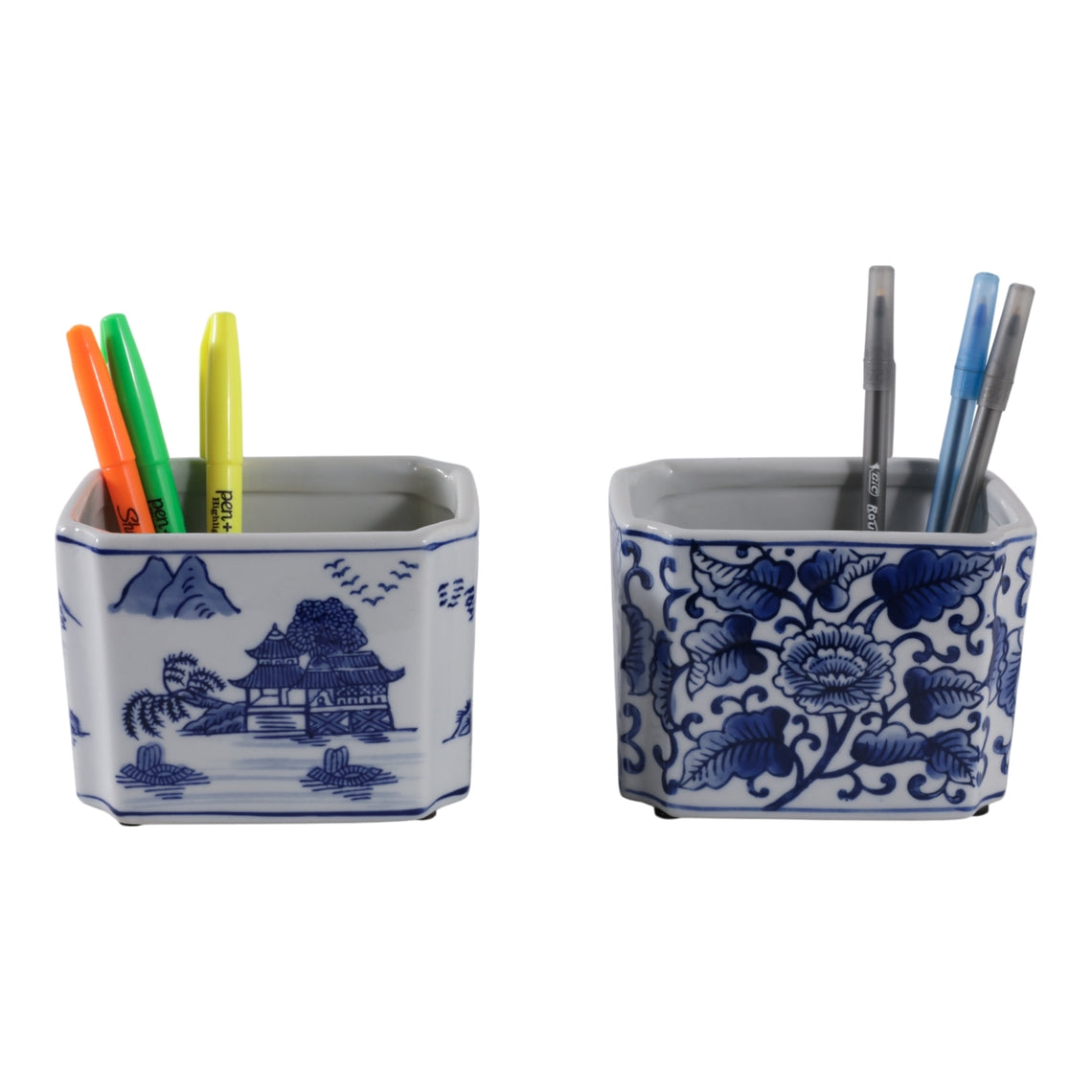 Two blue and white ceramic rectangular pencil cups with landscape and floral patterns.