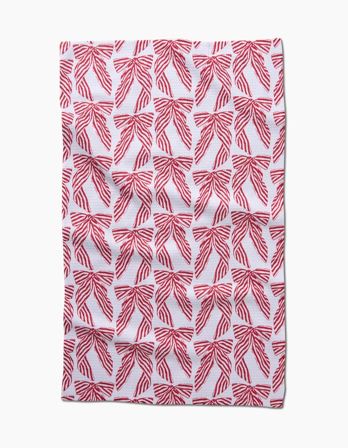 Holiday tea towel with waffle weave construction in red featuring a festive snowflake pattern and hang loop.