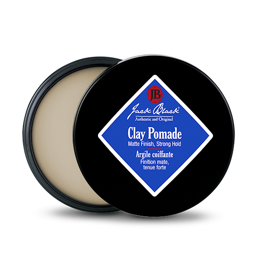 Jack Black Clay Pomade in a black tin with a blue diamond label, showing the matte product inside.