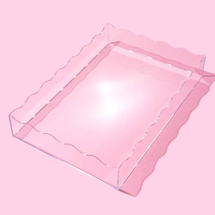 Clear pink acrylic wavy rectangle tray on a pink background.