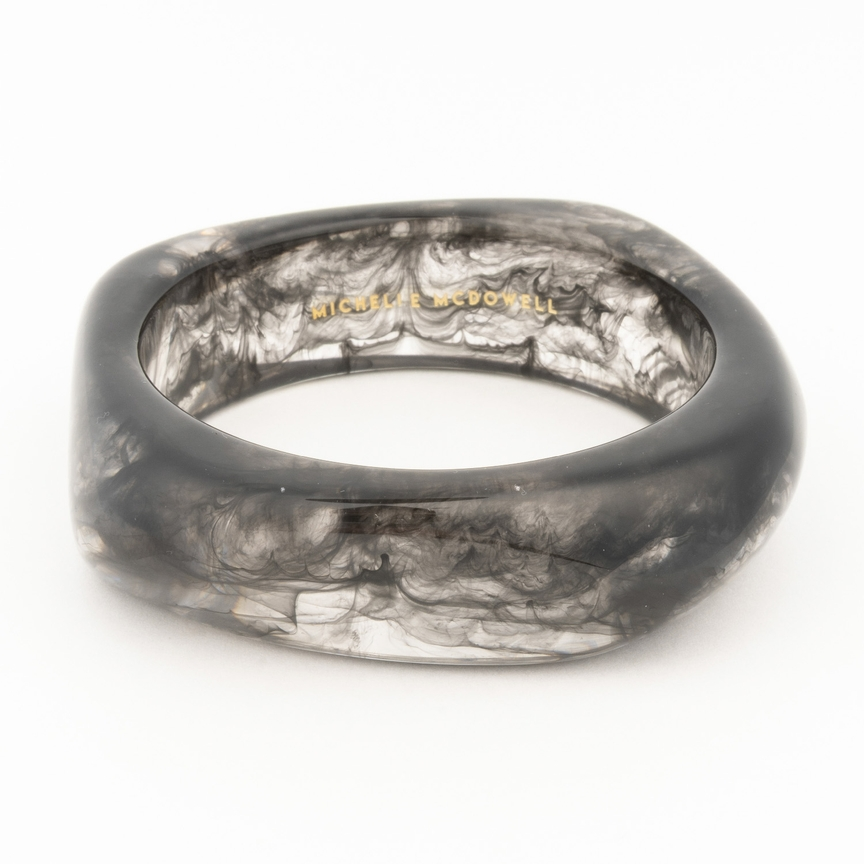 Tillie Bangle in a smoky black and clear marbled resin with a thick, organic silhouette.