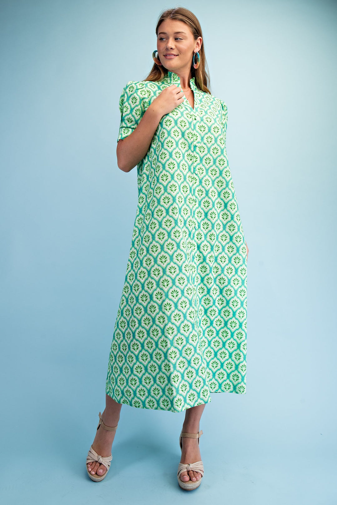 Woman wearing the Lara Bright Printed Button Down Midi Dress in green and white with ruffled collar.
