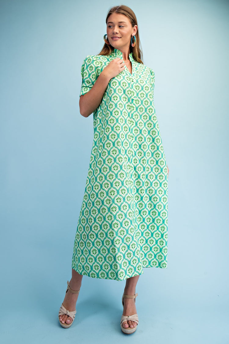 Woman wearing the Lara Bright Printed Button Down Midi Dress in green and white with ruffled collar.
