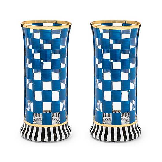 Two highball glasses with blue and white checkered patterns and black and white striped bases.