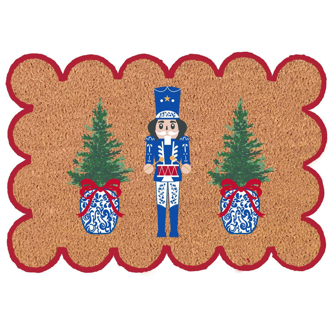 Scalloped coir doormat with a blue nutcracker between two Christmas trees in ginger jars.