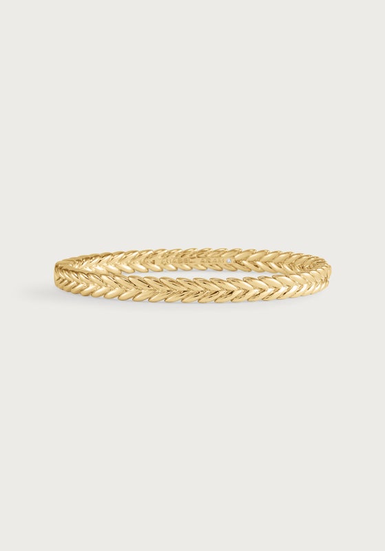 Thin 18K gold plated brass hinged bangle with a sculptural braided reins motif.