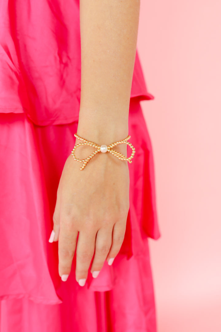 6.75-inch gold-filled bead bracelet featuring a decorative bow accent.