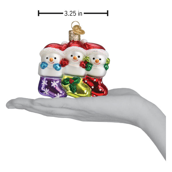 Snow Family of 3 glass ornament featuring three snowmen in colorful stockings held in a hand.