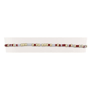 Crimson and white seed bead bracelet with gold accents on elastic cord