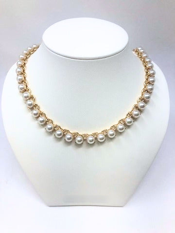 Gold tone chain necklace with a row of round white faux pearls on a white jewelry bust.