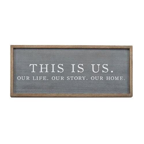 Wooden 'This Is Us' plaque with engraved text on a natural finish background.