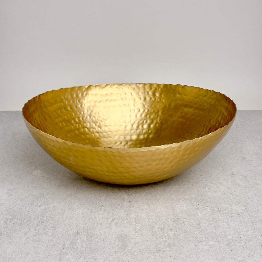 Gold hammered aluminum oval bowl with a torn edge design, 14 inches.