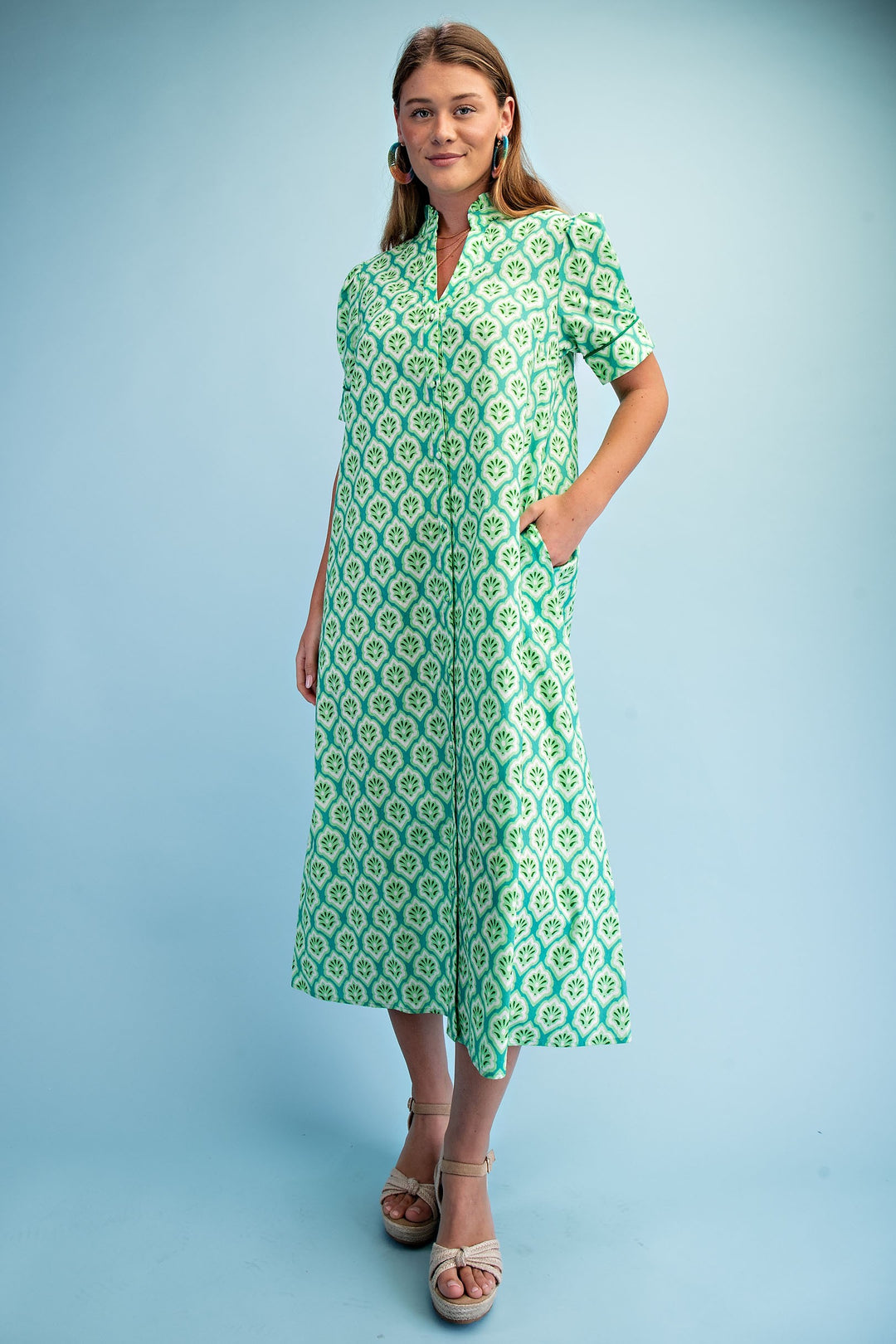 Woman in the Lara Bright Printed Button Down Midi Dress with a ruffled collar and short sleeves.