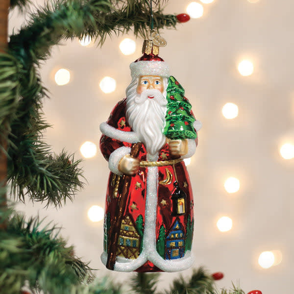 German Santa ornament with red hat, white beard, green suit, gold trim, and black boots.