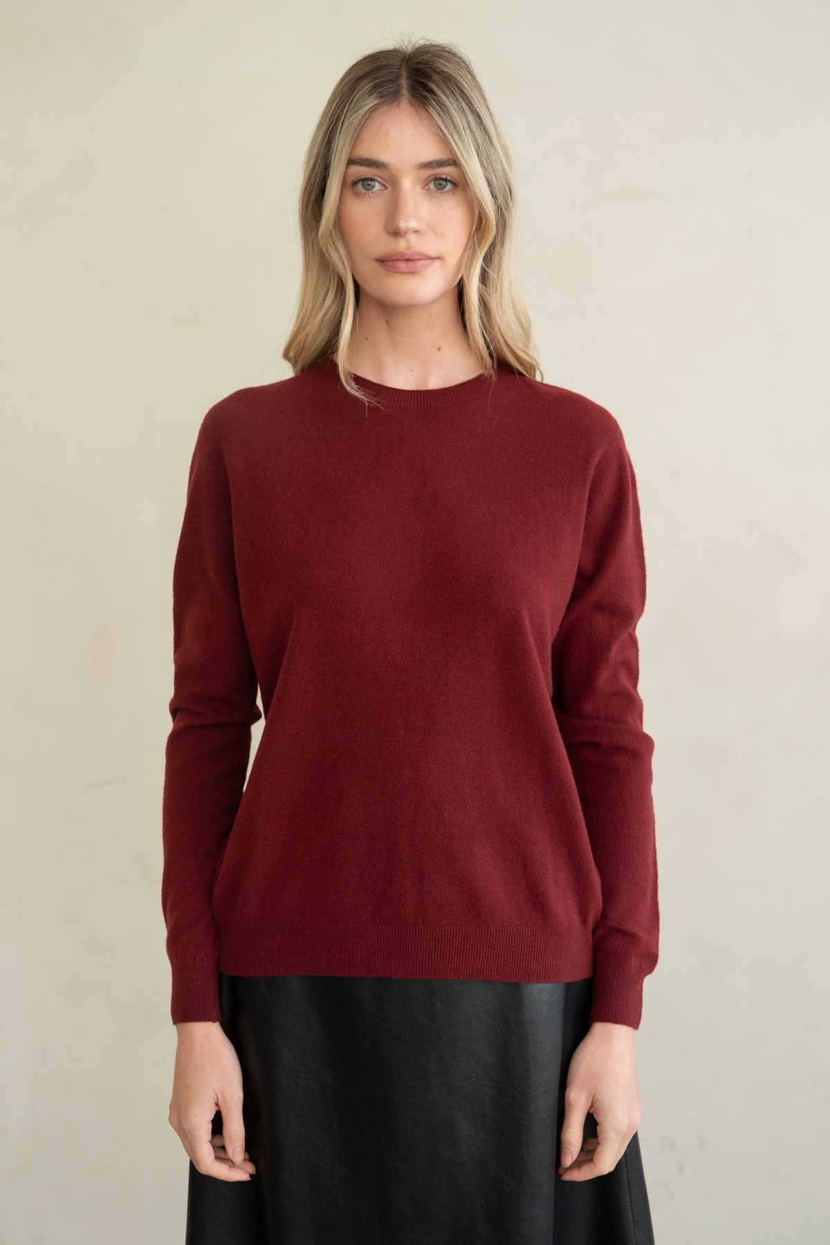 Woman wearing a burgundy Ellen Soft Classic Crew Neck Sweater with a black leather skirt.